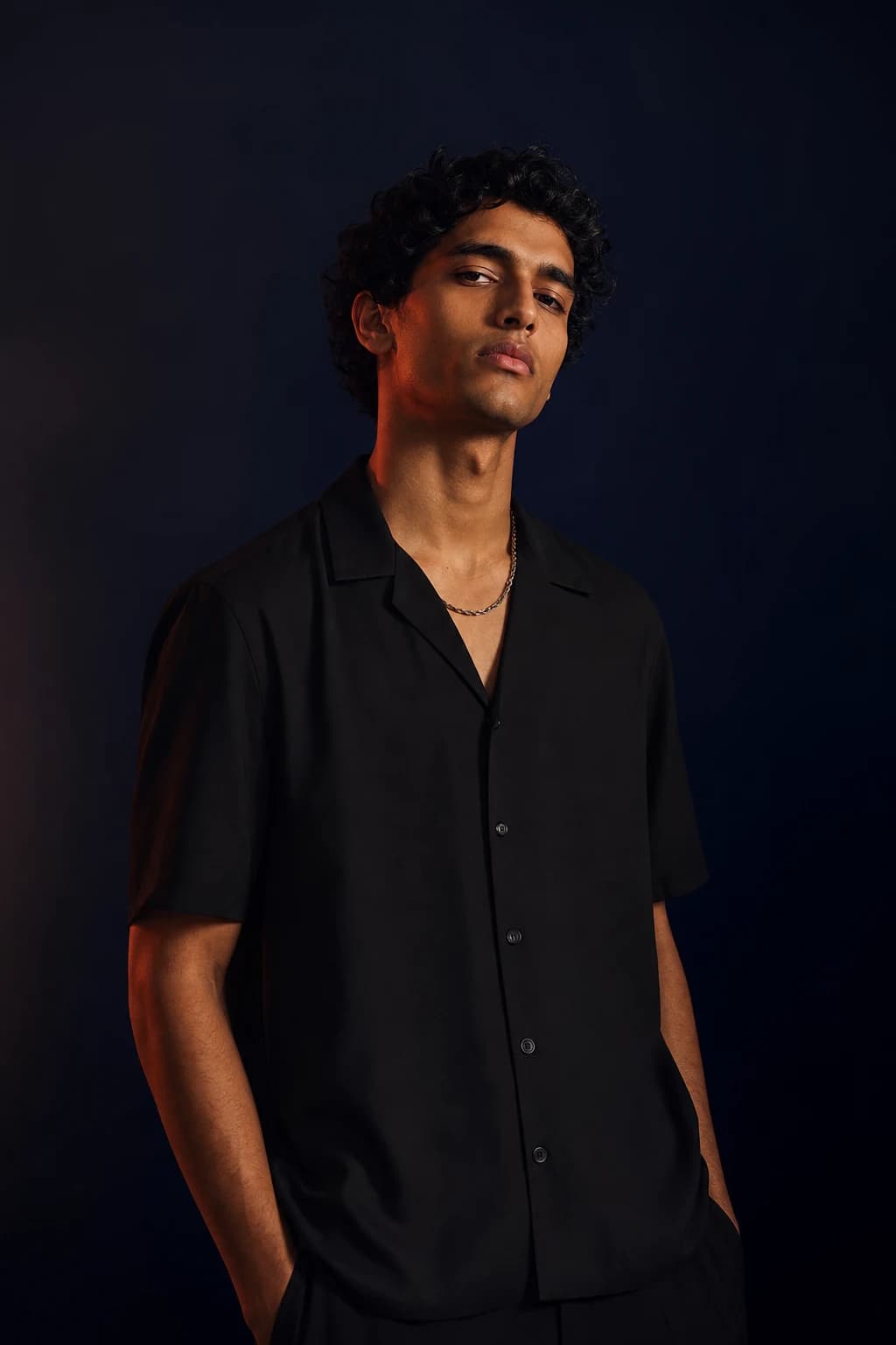 Young man in a black camp-collar shirt